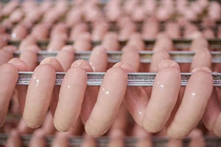 食品加工业的香肠车间肉类加工厂储藏室衣架上的生香肠